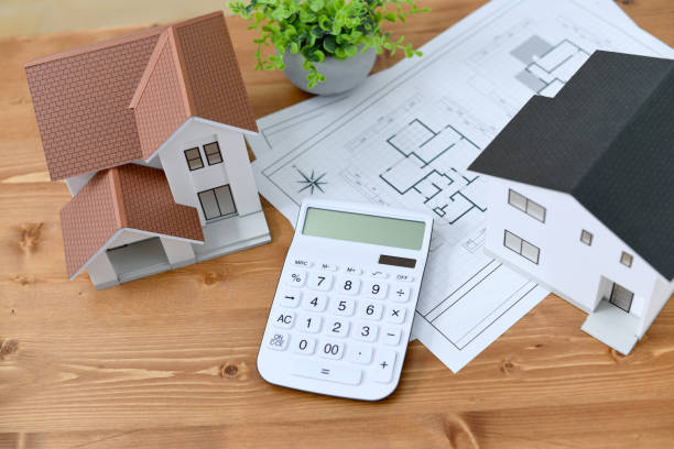 Propriétaires qui analysent leur projet de vente immobilière avec un ordinateur et des documents de financement