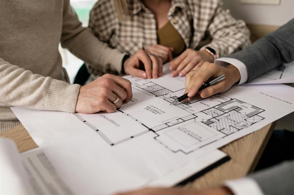 Conseiller immobilier qui conseille une cliente lors d'un rendez-vous