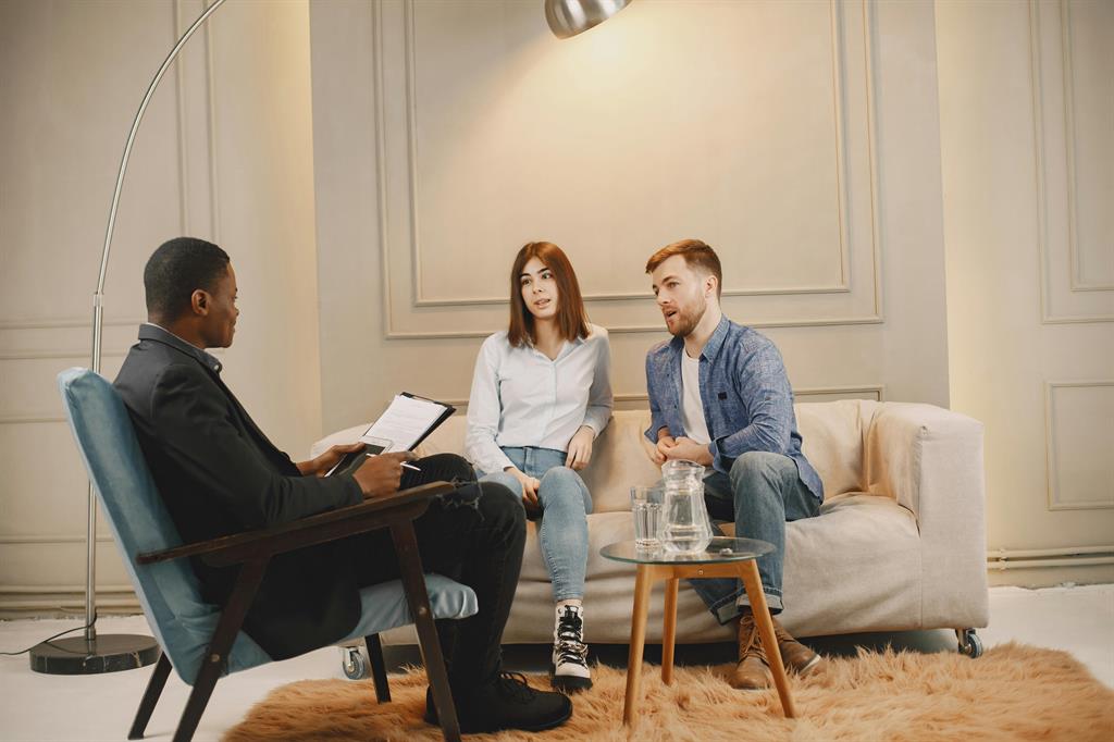 Conseiller immobilier qui conseille une cliente lors d'un rendez-vous