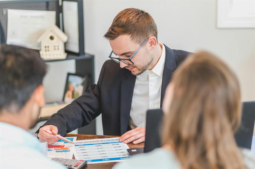 Conseiller immobilier qui conseille une cliente lors d'un rendez-vous